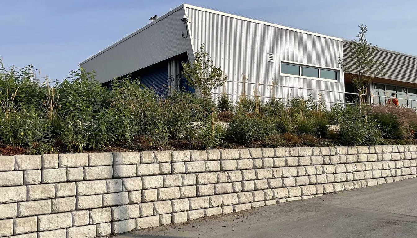 Large concrete masonry retaining wall with natural block texture in front of a commercial building in Sioux Falls, SD